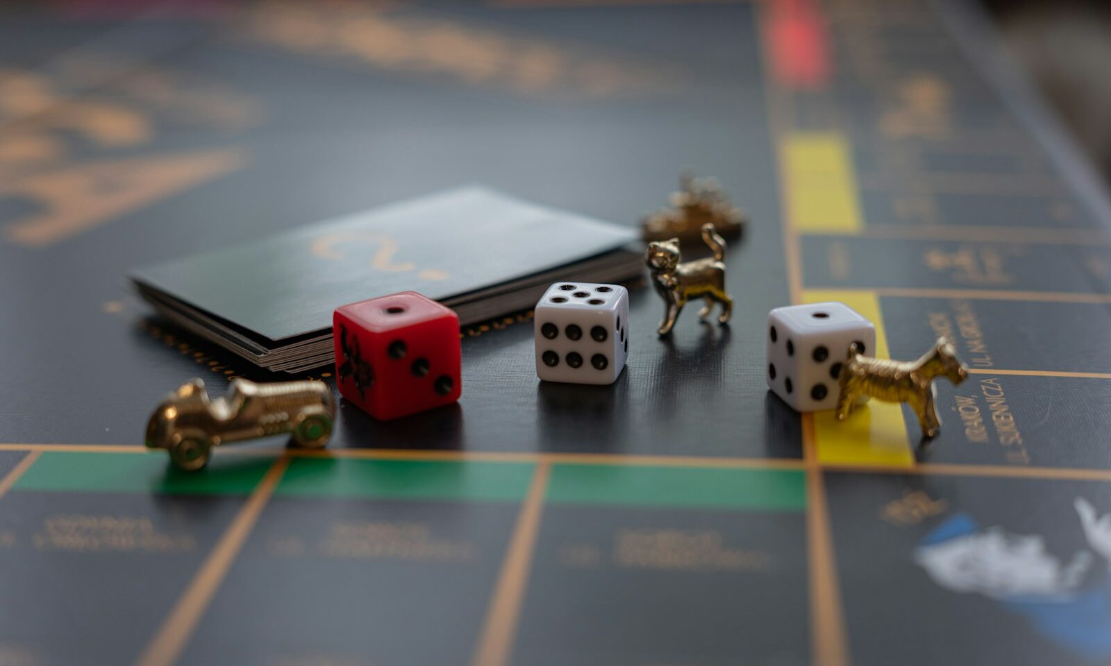 Dice and gold-colored tokens on a Monopoly game board