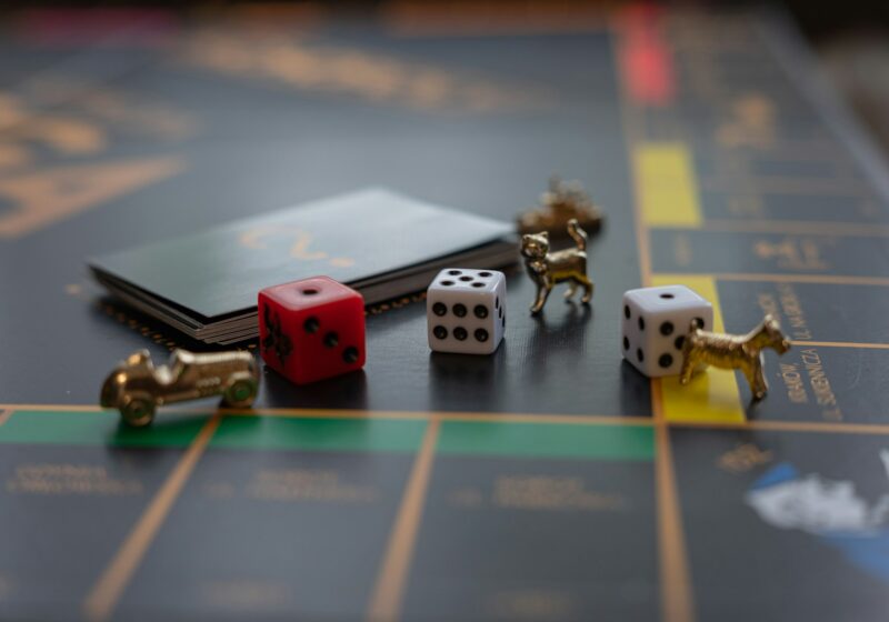 Dice and gold-colored tokens on a Monopoly game board