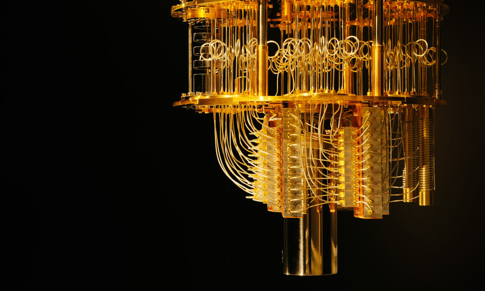 Gold-coloured IBM quantum computing apparatus with stacked plates and connecting cables