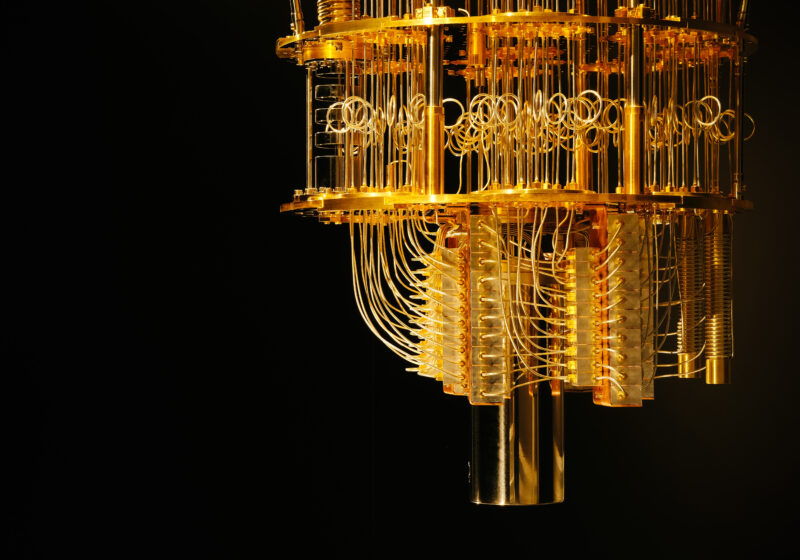 Gold-coloured IBM quantum computing apparatus with stacked plates and connecting cables