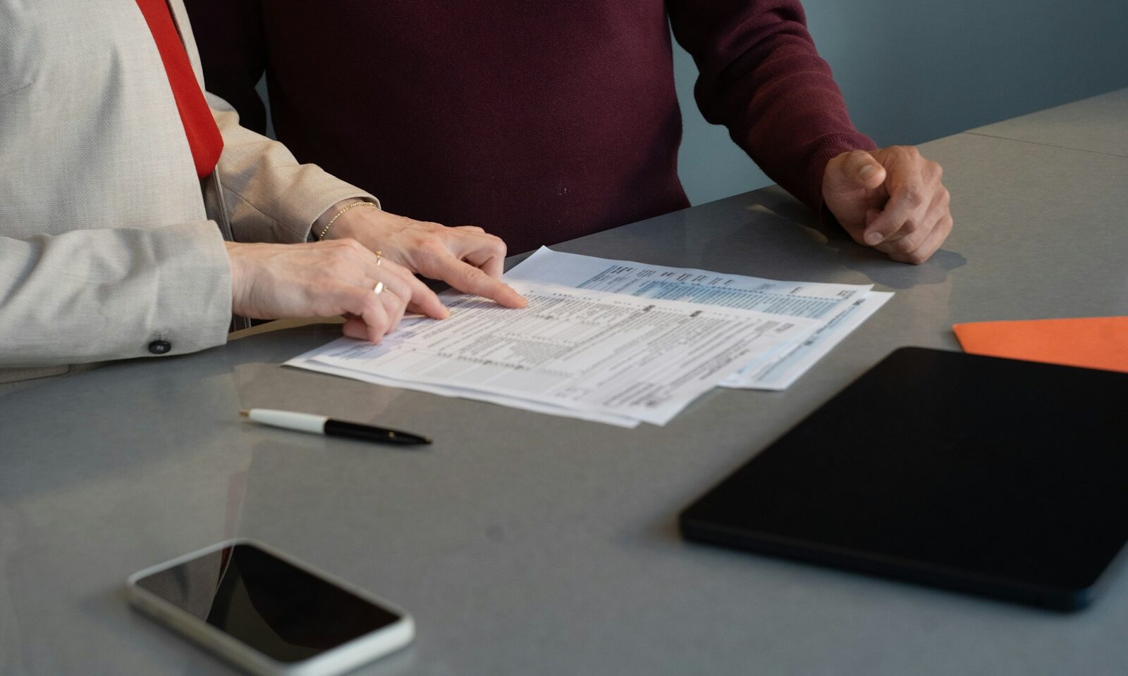 Two professionals reviewing documents at a conference table, illustrating board governance